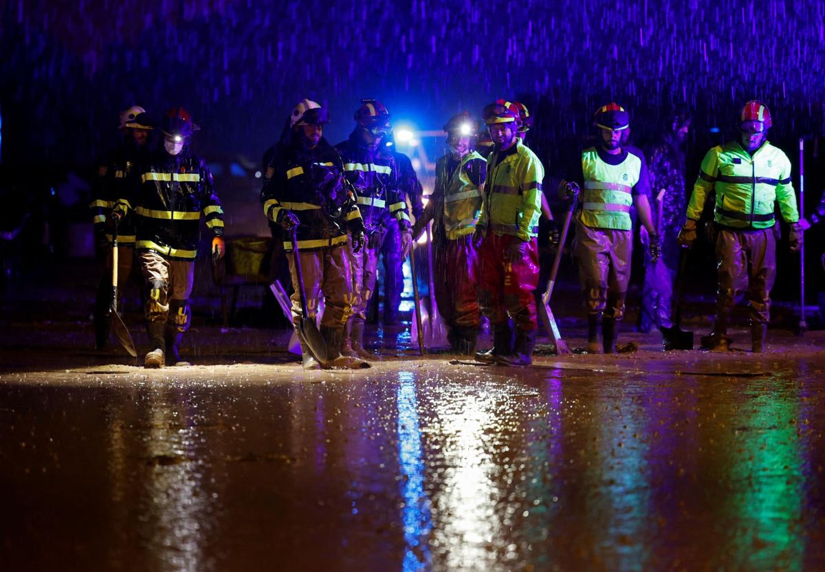 Equipos de rescate, bajo la lluvia en Paiporta, este domingo.