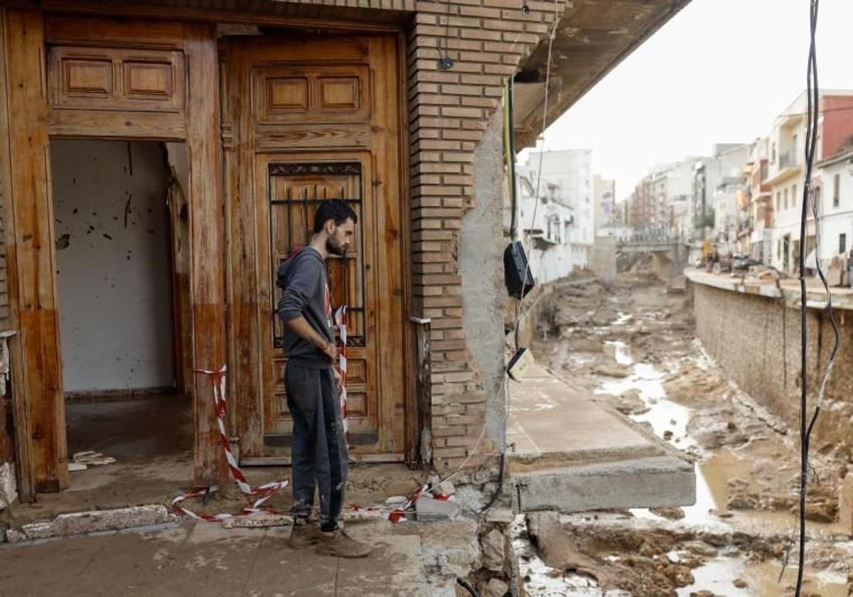 Un hombre observa el estado de su vivienda y de las calles en Chiva tras la DANA