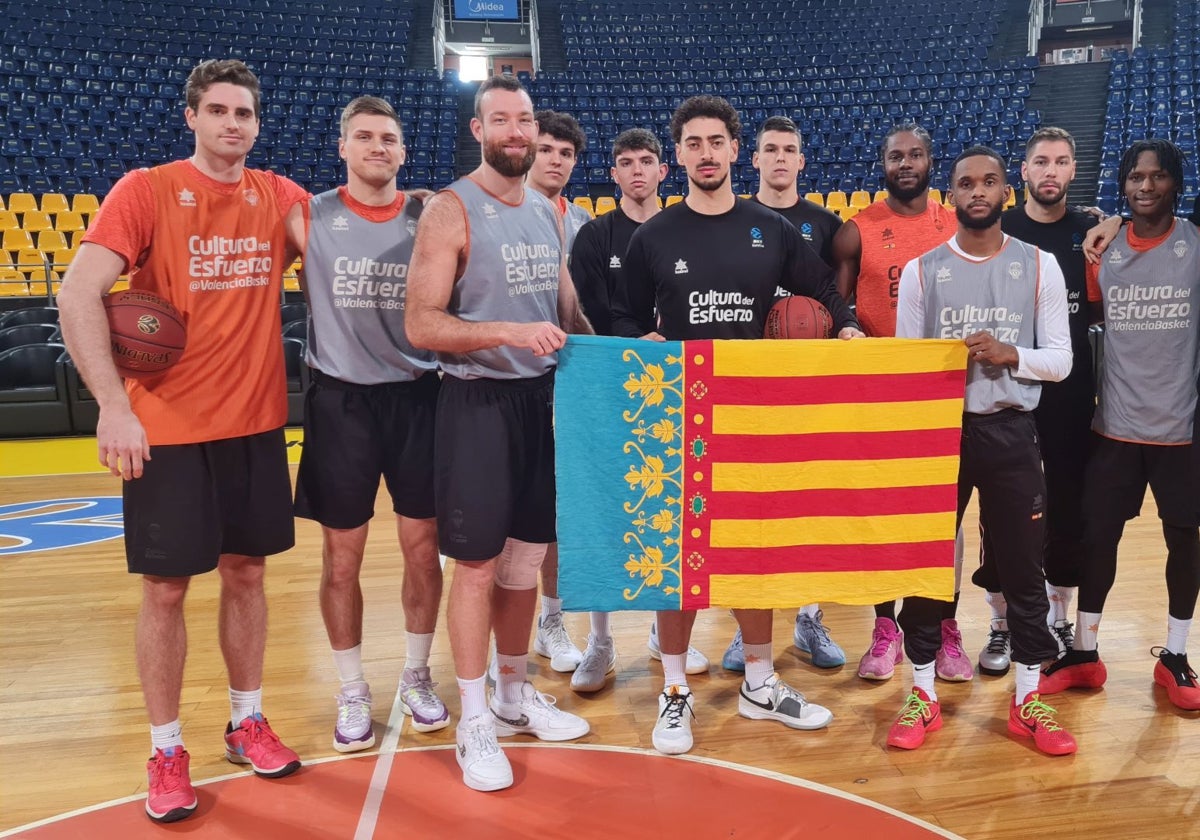 La plantilla del Valencia Basket posa con la Senyera antes del entrenamiento en el Nikos Gallis.