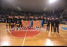 Los dos equipos, y los árbitros, posan con la Senyera antes del partido.