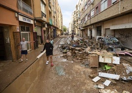 Una calle llena de barro y escombros en Benetússer.