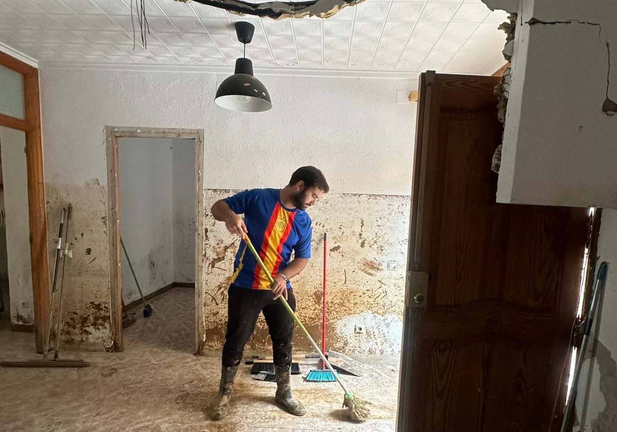 Imagen principal - Carles y su novia Fátima, limpiando su casa de Benetússer de donde han tenido que irse por el barro.