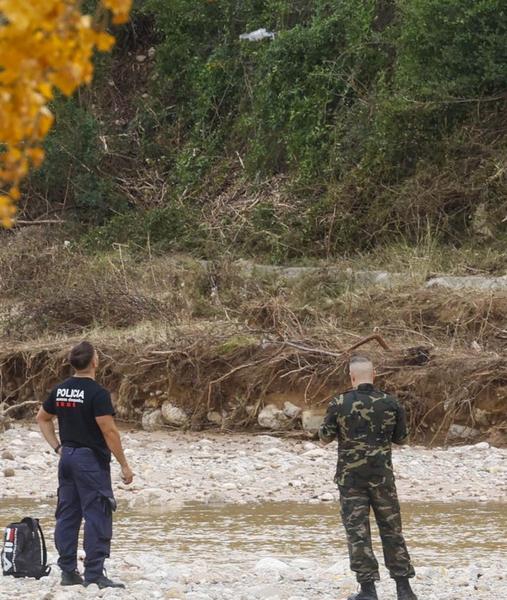 Imagen secundaria 2 - De arriba a abajo: restos de la finca arrasada, un vecino cargando agua y policías y militares mientras buscan el cuerpo de Javier con un dron. 