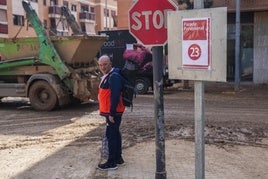 Un hombre, junto a una parada provisional de la línea 23 en Sedaví.