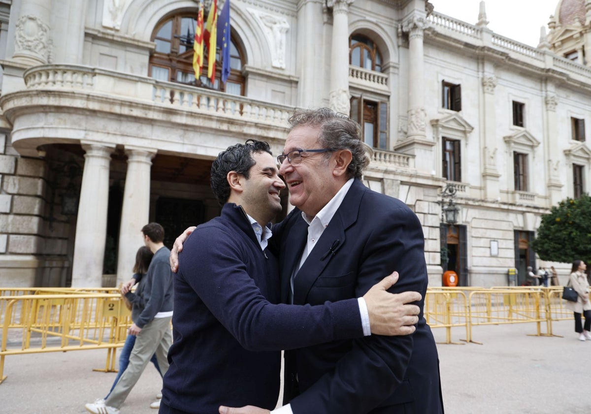 Imagen principal - Ambos senadores reproducen ese abrazo. Después conversan e, incluso, les regalan un obsequio en una de las floristerías de la Plaza del Ayuntamiento de Valencia.