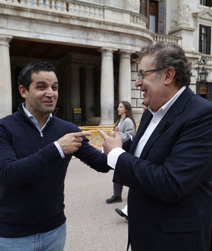 Imagen secundaria 2 - Ambos senadores reproducen ese abrazo. Después conversan e, incluso, les regalan un obsequio en una de las floristerías de la Plaza del Ayuntamiento de Valencia.