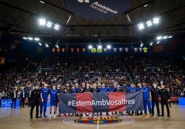 Los jugadores del Valencia Basket y el Barça, junto a los árbitros, posan con una pancarta de apoyo a las víctimas por la DANA.