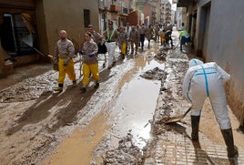 Voluntarios retiran barro en las calles de Paiporta.