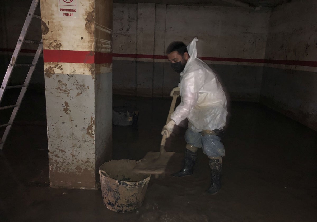 Imagen principal - Andrés achica agua en un aparcamiento subterráneo de Benetússer.