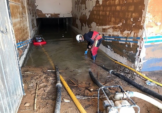 Un bombero colabora en la toma de muestra en un garaje inundado.