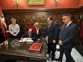 González firma en el libro de oro de la ciudad.