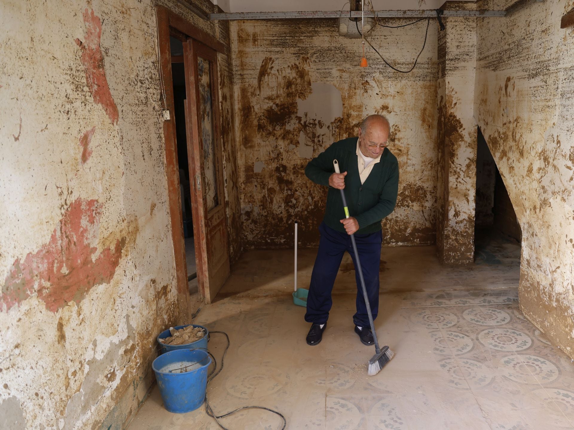 Manuel Tarazona, un vecino de Paiporta, barre su casa afectada por la DANA.