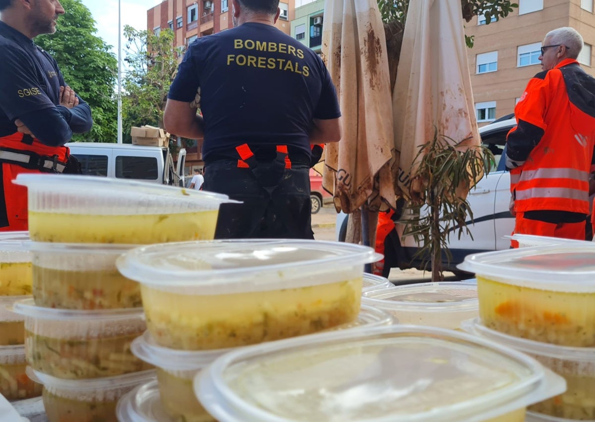 Imagen secundaria 1 - En las dos primera fotos, Edi, de rojo, junto a los voluntarios que le ayudan a hacer la comida y en la inferior el estado del mobiliario de la cocina de su bar tras la barrancada. 