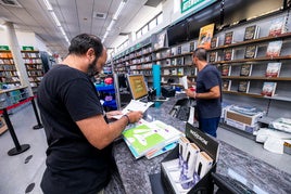 Un hombre compra libros de texto en un establecimiento.