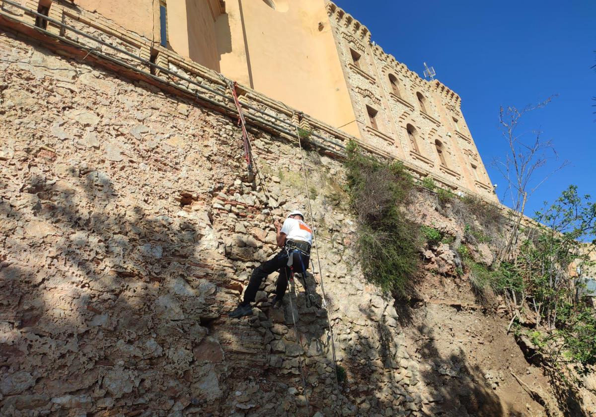 Trabajador limpiando la muralla del Castillo de Cullera.