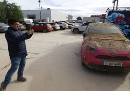 El gerente de un concesionario fotografía un vehículo arrasado por el temporal.