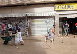 Voluntarios ayudando a limpiar comercios afectados por la DANA.