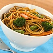 Espaguetis de trigo integral y vegetales salteados con zanahorias y brócoli, una idea de receta saludable con superalimentos.