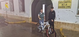 Una agente de la Guardia Civil entrega a su propietario la bicicleta que le fue robada.