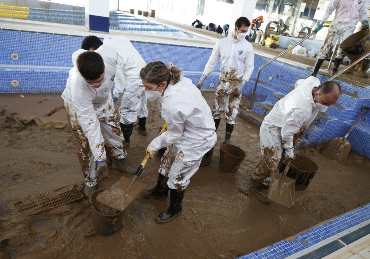 Voluntarios limpian la piscina municipal de Picanya.