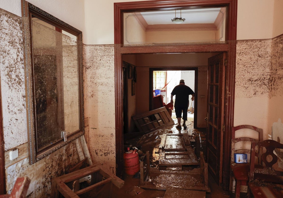 Una persona camina por su casa de Paiporta, arrasada por la tremenda crecida del barranco del Poyo.