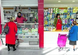 Dos trabajadores autónomos atienden a sus clientas en el mercado de Benetússer habilitado para distintos negocios tras la DANA.