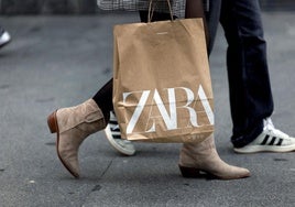 Una mujer lleva una bolsa de Zara, la cadena estrella del grupo Inditex.