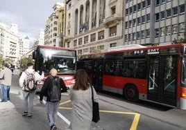 Pasajeros se suben a bordo de un autobús de la EMT en la plaza del Ayuntamiento de Valencia.