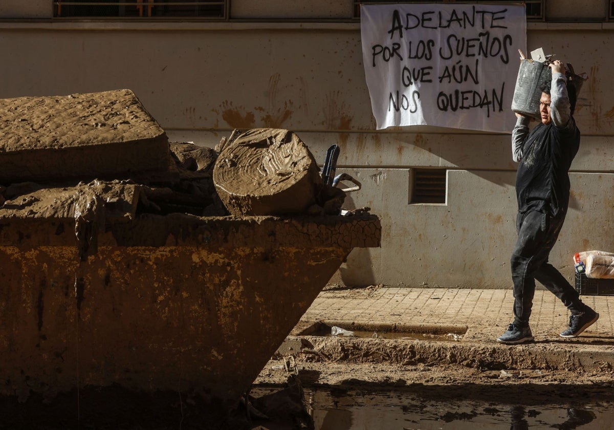 Un ciudadano retira escombros en Catarroja.