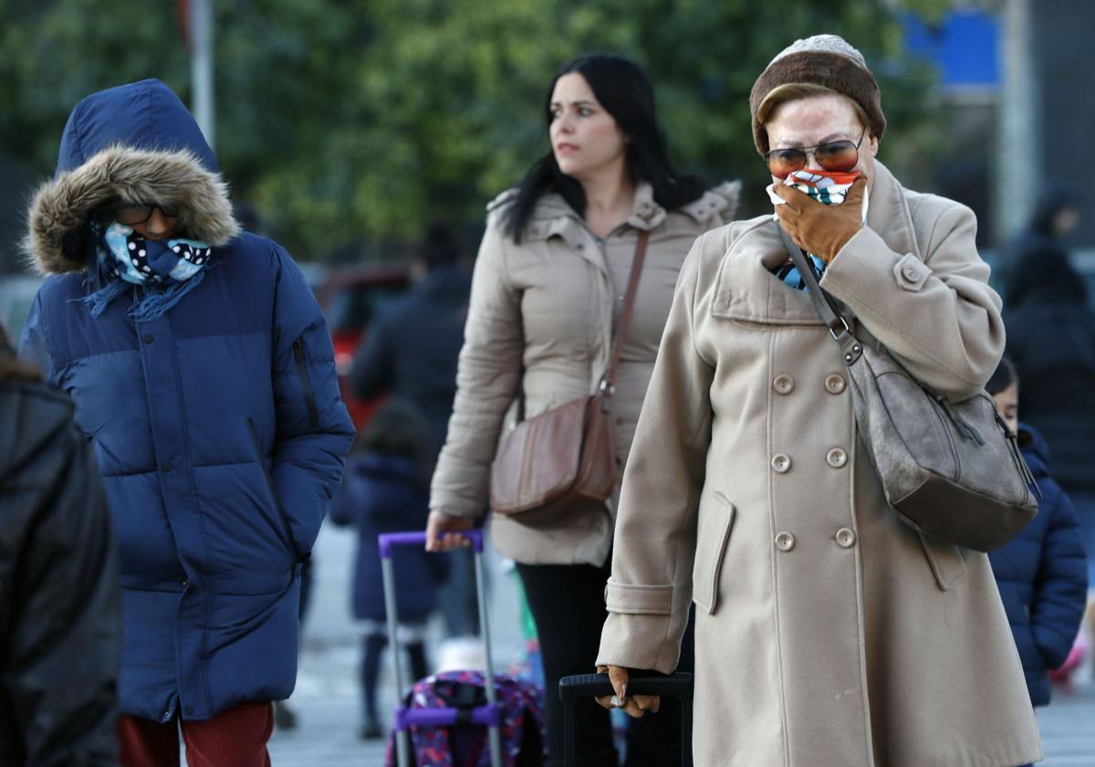 Una mujer abrigada por la calle.