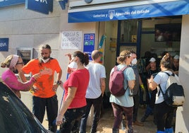 Cola en una administración de loterías de Benetússer, que abrió tras la DANA.