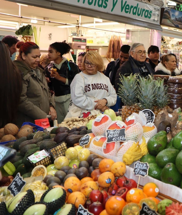 Imagen secundaria 2 - Paradas y pasillos del Mercado CentraL, llenos de clientes.