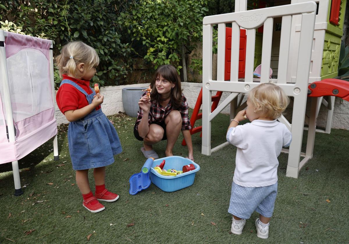 Yuliia juega con María Aurora y Carolina en el jardín de la casa en Campo Olivar.