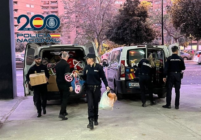 Los policías sacan los juguetes de dos furgones.