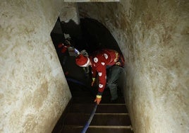 Un militar de la UME, con un gorro de Papa Noel, durante tareas de limpieza en un garaje de Benetússer.