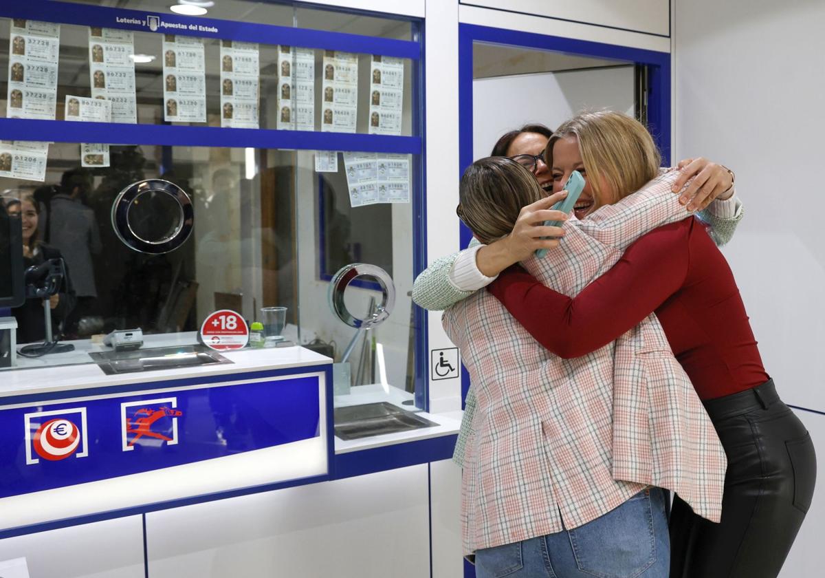 Unas loteras celebran la entrega de un premio de lotería.