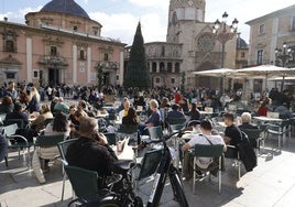 Una concurrida terraza en la plaza de la Virgen de Valencia.