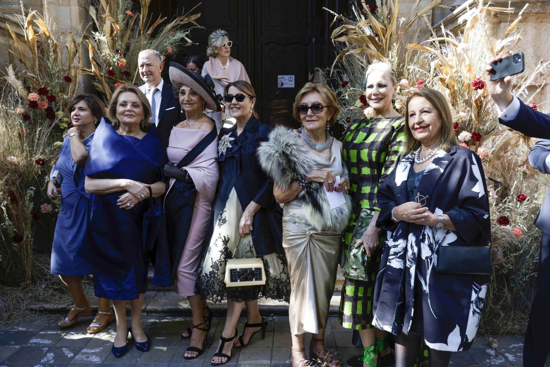 Las amigas de la madre de la novia, Carmen de Rosa, en la puerta de la iglesia, que fue adornada con espigas.