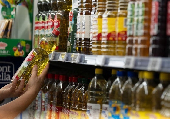 Botellas de aceite en el lineal de un supermercado.