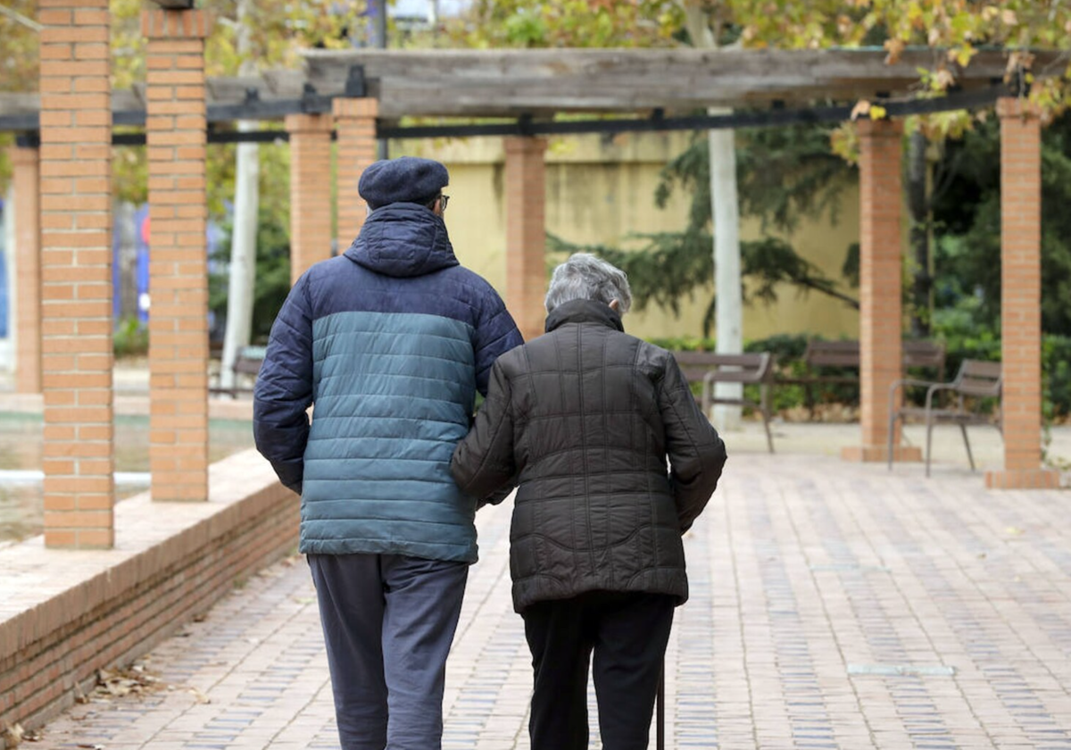 Una pareja camina por un parque en Valencia.