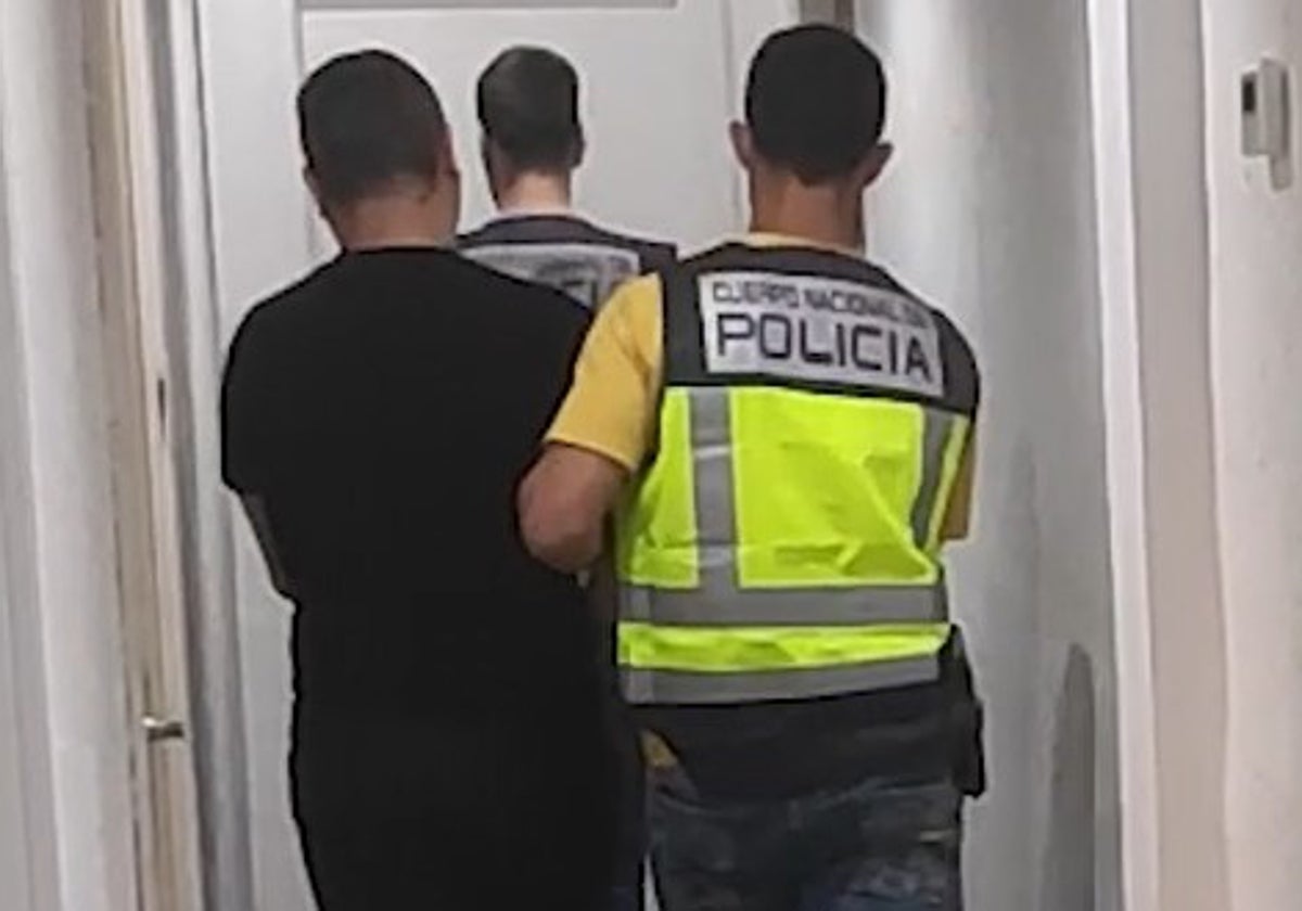 Dos policías trasladan al detenido a una habitación para interrogarlo.