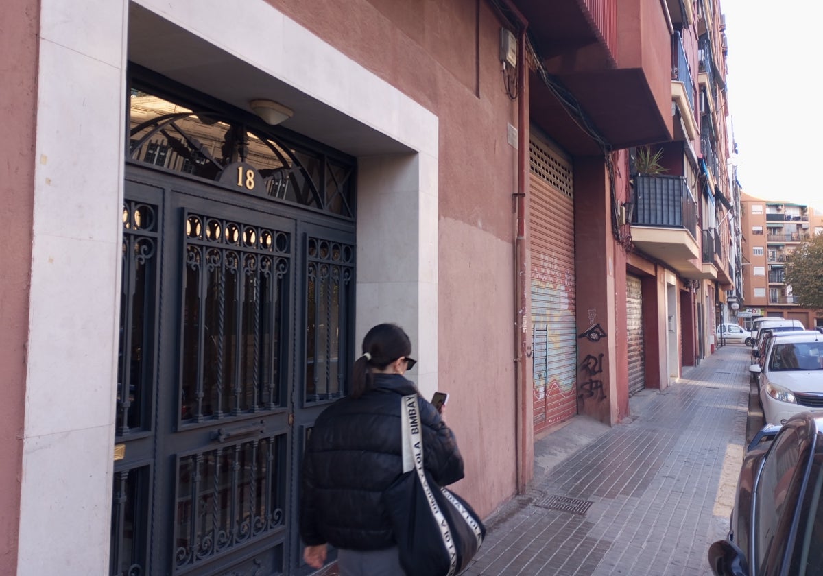 Una joven pasa junto al edificio donde residía la anciana fallecida.