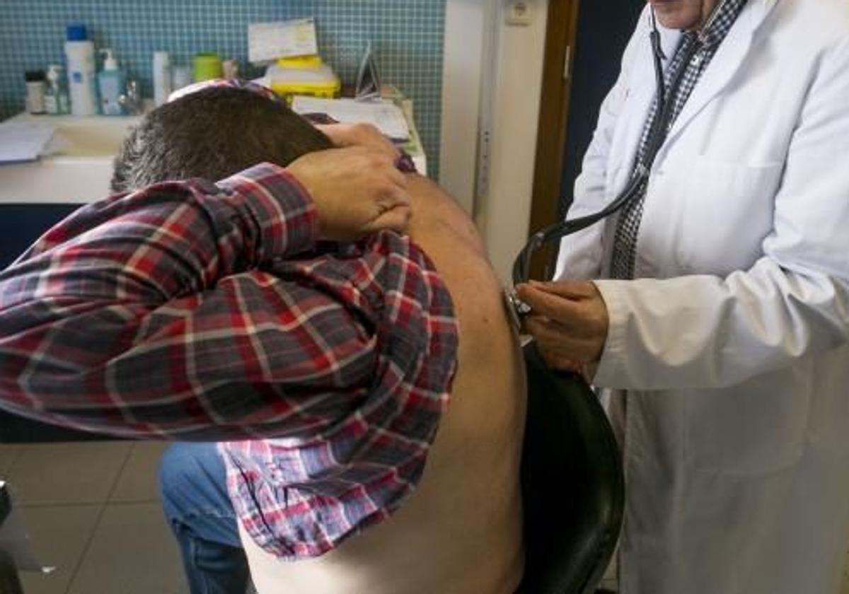 Un médico atiende a un paciente en su consulta.