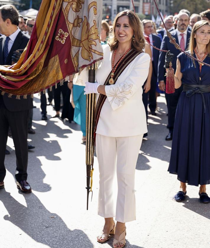 Imagen secundaria 2 - Arriba, vestido de algodón y lino con estampados de hojas de ficus que lució en un día de Fallas. A la izquierda, traje en color naranja para la procesión cívica de 2024. A la derecha, con un traje blanco, un color que usa mucho, en la procesión cívica de 2023.