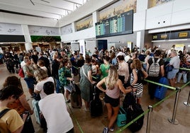 Pasajeros hacen cola en el aeropuerto de Valencia.