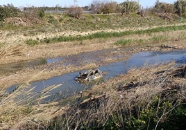 Un vehículo sin retirar en la rambla del Poyo a su entrada en la Albufera.