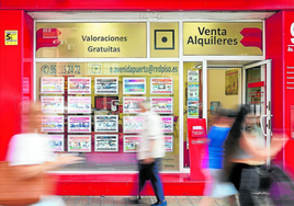 Varias personas caminan junto a la puerta de una inmobiliaria de Valencia, en una imagen de archivo.