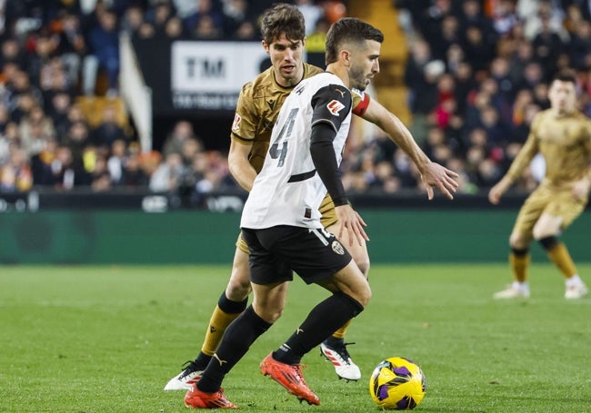 Gayà controla el balón ante la presión de Aritz Elustondo.