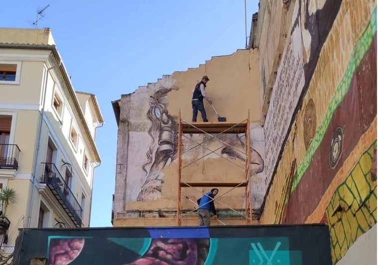 Operarios pintando sobre la parte del mural que es obra de Espinar.