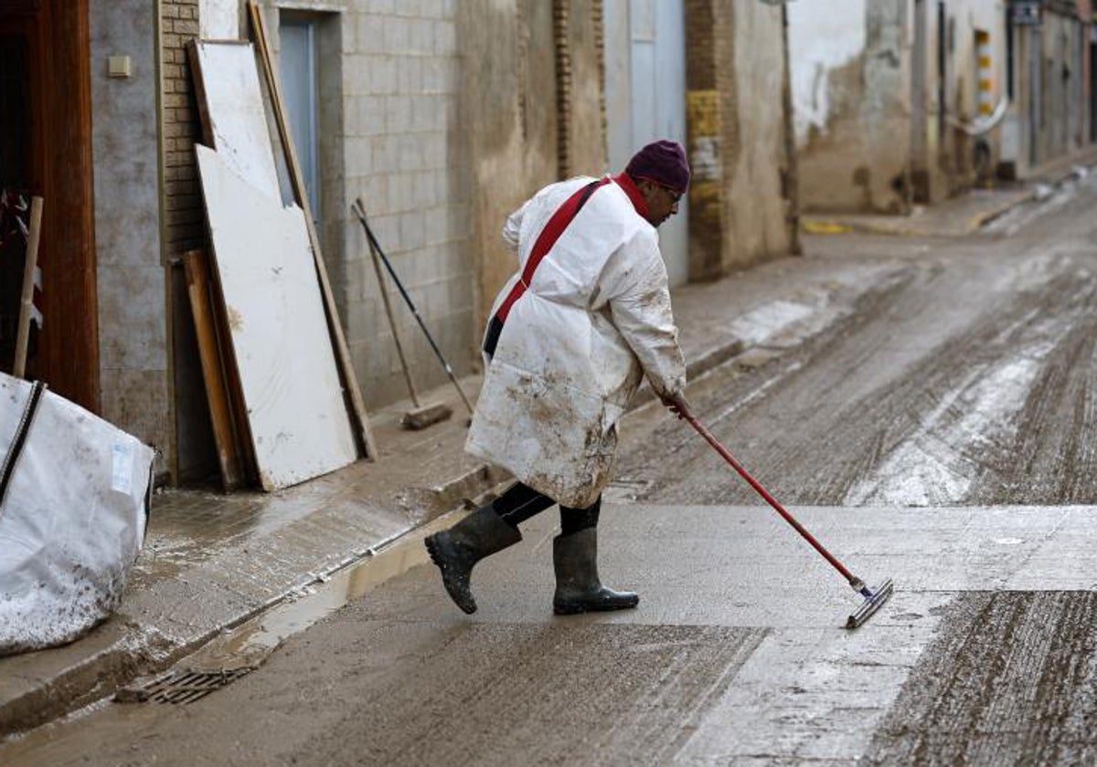 Un hombre limpia una calle en Paiporta en los días posteriores a la dana.